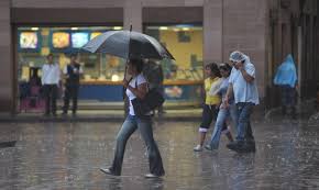 Persona con sombrilla bajo la luvia 
