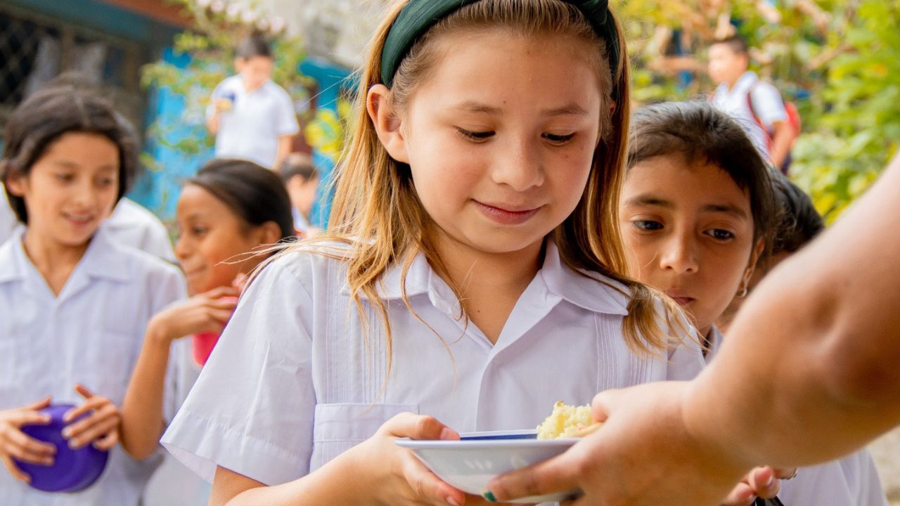 Niña recibiendo su merienda escolar